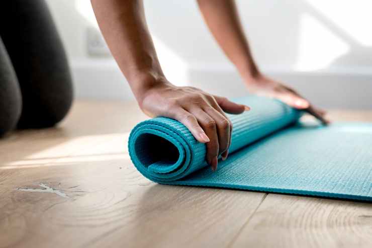 person rolling green gym mat